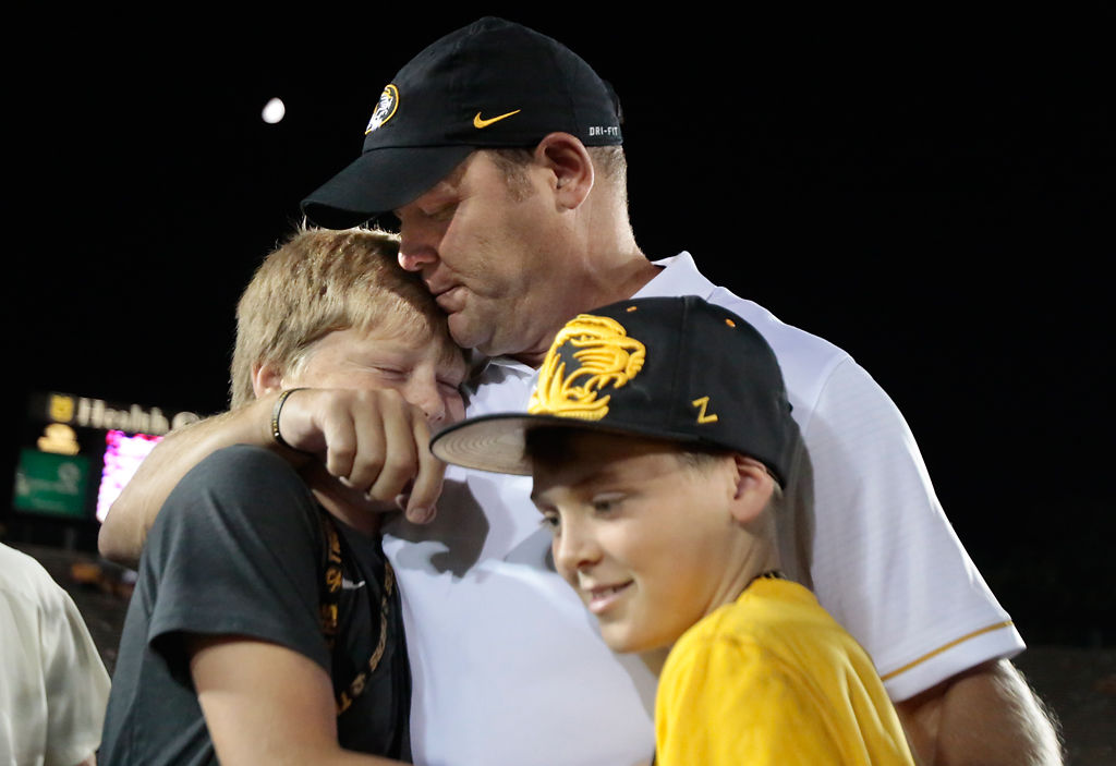 Barry Odom hugs his sons